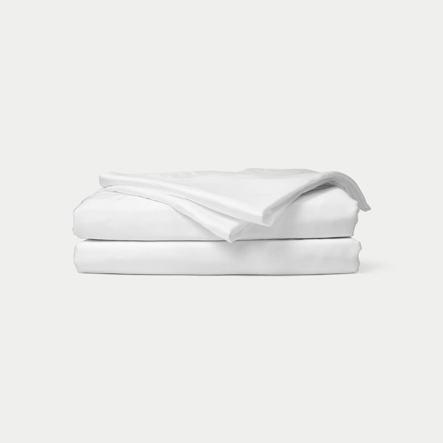 A neatly made bed with bamboo sheets