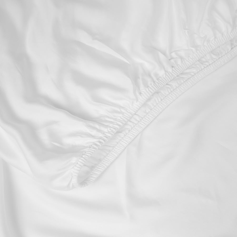 Deep-pocket fitted bamboo sheet secured around a mattress